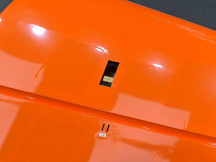 Close-up of a bright orange surface with a small servo slot on it.