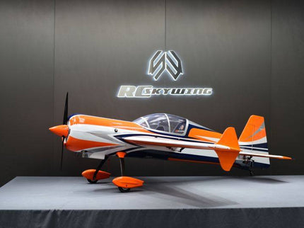 Orange and white airplane on a gray platform with a dark background featuring a logo.
