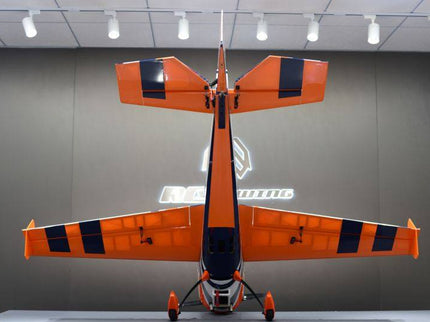 Orange and black model airplane on display against a gray background with a logo.