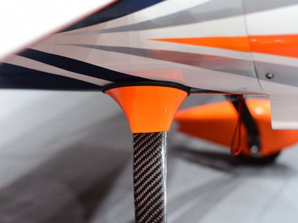 Close-up of a model airplane with orange, black, and white design on a gray background