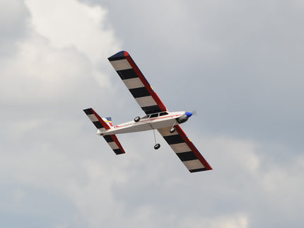 Phoenix Model Domino 62” Trainer with striped wings flying against a cloudy sky