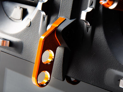 Close-up of a black and orange metal component on a gray background