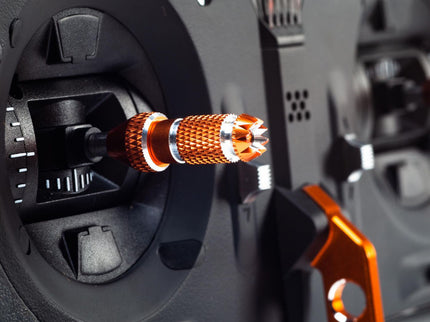 Close-up of an orange and silver mechanical component on a black background