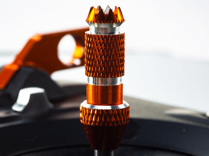 Metallic orange and silver car knob on a blurred car interior background