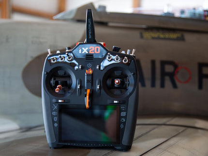 Black and orange remote control device with 'ix20' branding on a blurred background