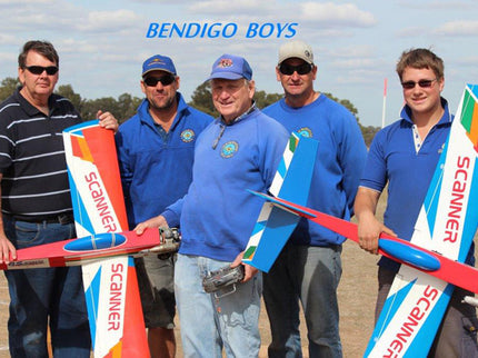Five men holding Phoenix Model PH006-SCANNER 57" model airplanes with 'Bendigo Boys' branding against a clear sky.
