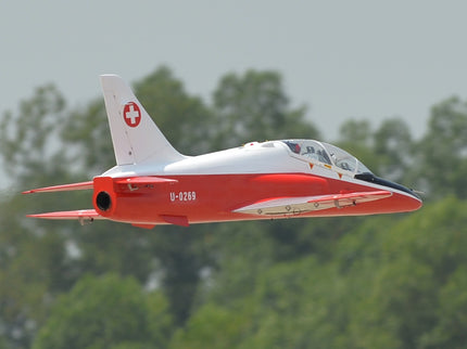 Phoenix Model BAE Hawk Jet 72" ARF V2 Red and white jet plane flying against a green forest background