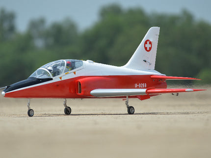 Phoenix Model BAE Hawk Jet 72" ARF V2 Red and white jet on a runway with trees in the background