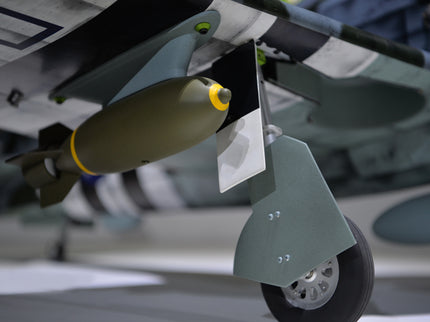 Phoenix Model P-47 Thunderbolt 79" ARF V2 with Electric Retracts Close-up of a bomb attached to an aircraft wing with a blurred background