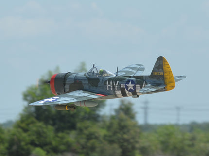 Phoenix Model P-47 Thunderbolt 79" ARF V2 with Electric Retracts Vintage military airplane flying against a clear sky with trees in the background