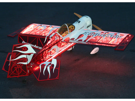 Model airplane with red and white design on a dark background