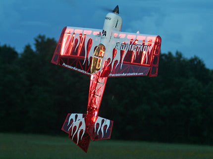 Model airplane with red and white design against a dark background