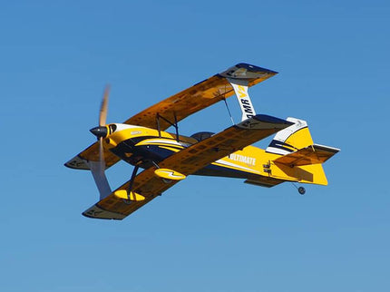 Yellow biplane with blue accents flying against a clear blue sky
