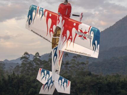 Model airplane with colorful design and branding against a mountainous background