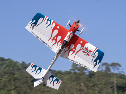 Red and blue model airplane with branding against a clear blue sky
