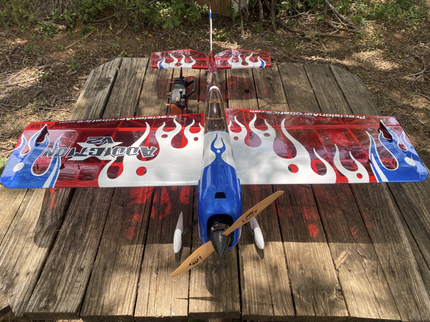 Model airplane with flame design on a wooden surface outdoors