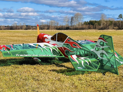 Colorful airplane on a grassy field with a clear sky