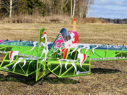 Green and pink robot-like vehicle with horse graphics on a grassy field.