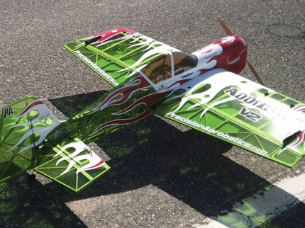 Model airplane with green and red design on a concrete surface