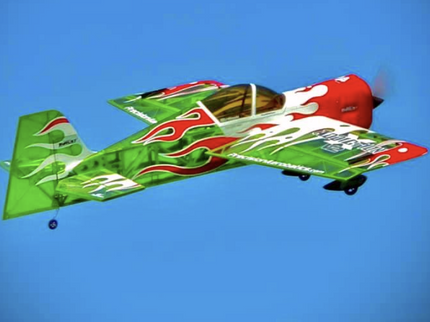 Colorful airplane with green, red, and white design flying against a clear blue sky.