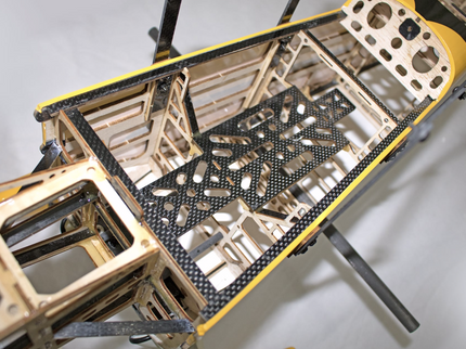 Close-up of a drone frame with carbon fiber and metal components on a white background