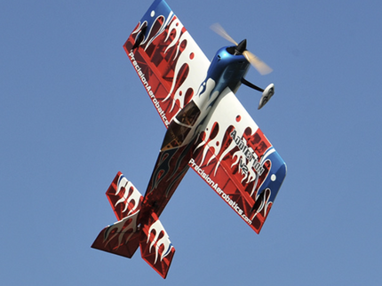Model airplane with red and blue design against a clear blue sky