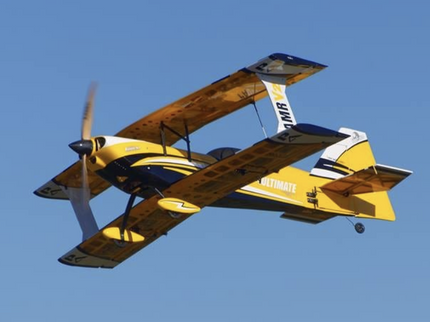 Yellow and blue airplane flying against a clear blue sky