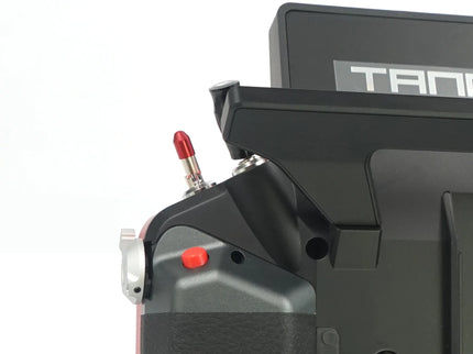 Close-up of a black electronic device with red buttons on a white background