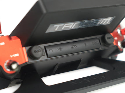 Close-up of a black and red electronic device with 'Tandem' branding on a white background