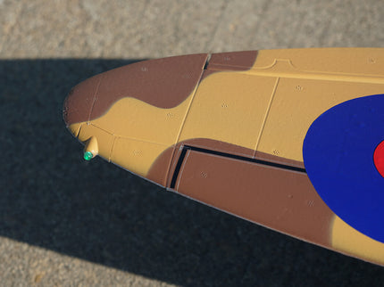 Close-up of a skateboard deck with a brown and beige design on a concrete surface.
