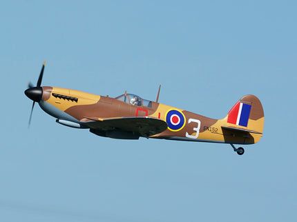 Vintage airplane with World War II-era camouflage pattern flying against a clear blue sky.