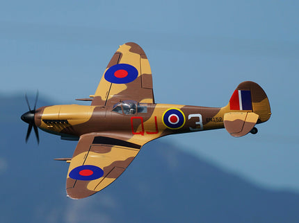 Camouflage airplane with British roundel insignia flying against a clear blue sky
