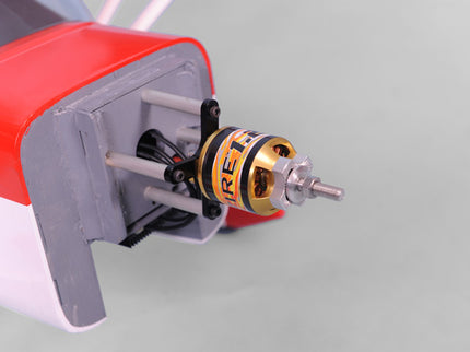 Close-up of a red Phoenix Model DECATHLON with a gold and black motor on a light gray background
