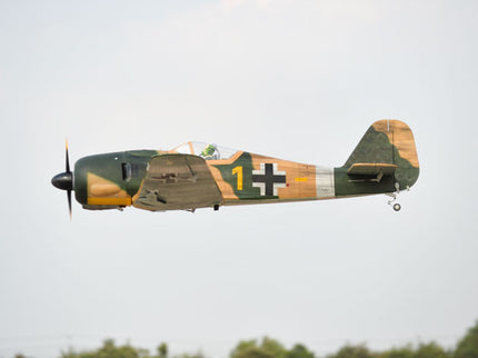 Phoenix Model Focke Wulf 55" with Electric Retracts Camouflage airplane with a visible cross symbol flying against a clear sky.