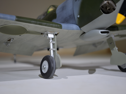 Phoenix Model Spitfire 55" W/Electric Retract Model airplane on a white surface with a blurred background