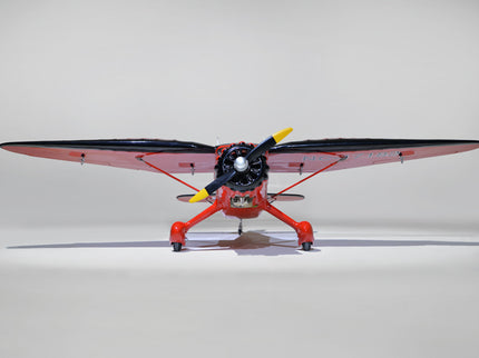 Phoenix Model STINSON RELIANT 68" ARF Model airplane with red body and black wings on a gray background