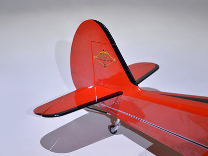 Close-up of a red Phoenix Model STINSON RELIANT 68" ARF airplane model with a white background