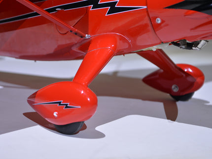 Close-up of a red Phoenix Model STINSON RELIANT 68" ARF model airplane on a white surface