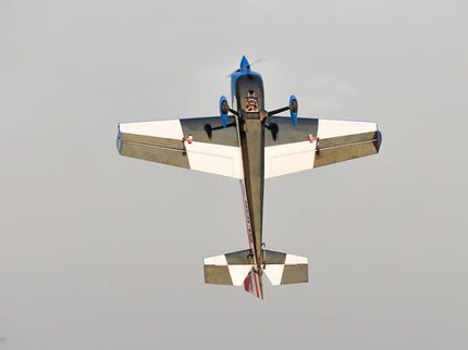 Phoenix Model SLICK 580 67" ARF V2 (20-26cc) underside flying against a clear sky