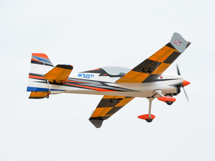 Phoenix Model SBACH 342 74'' ARF V2  with a checkered pattern flying against a clear sky
