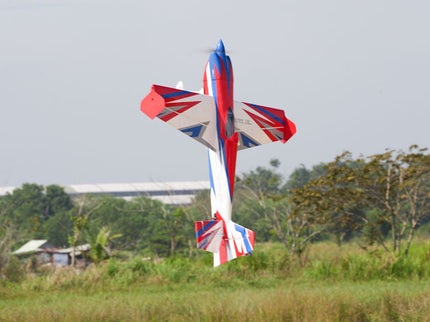Phoenix Model EDGE 540 V3 60''model flying in an open field with trees in the background