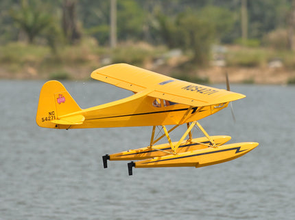 Yellow Phoenix Model PIPER J3 CUB  seaplane on water with a blurred natural background