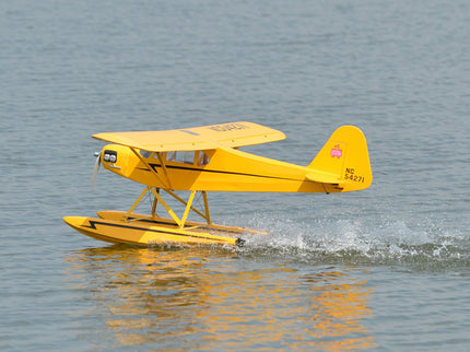 Yellow Phoenix Model PIPER J3 CUB seaplane on water with a clear background