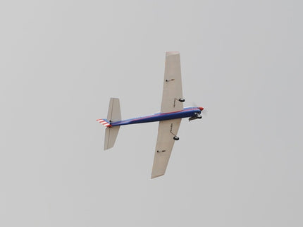 Phoenix Model TYPHOON 59" Size ARF flying against a gray sky